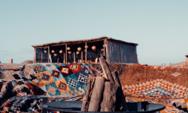 Colorful carpets and campfire in Marrakech desert camp offer a warm and adventurous atmosphere.
