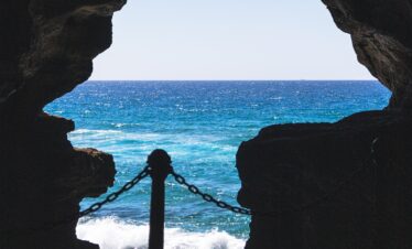 a view of a body of water from inside a cave