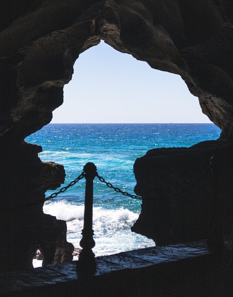 a view of a body of water from inside a cave