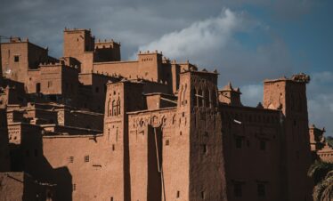 a large brown building sitting on top of a lush green field
