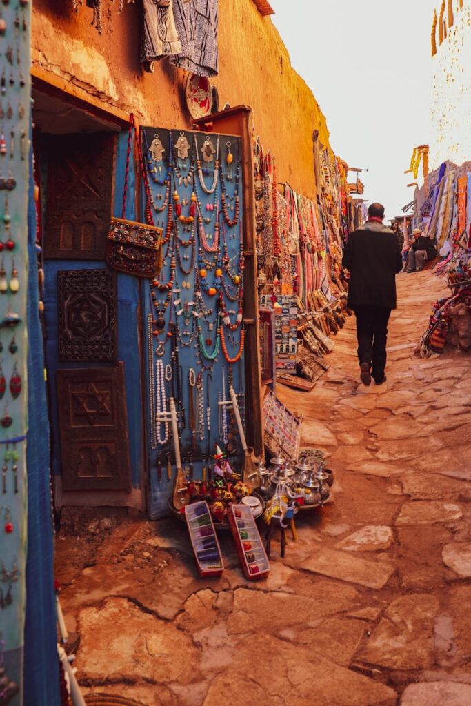 man in black jacket standing in front of blue and white painted wall