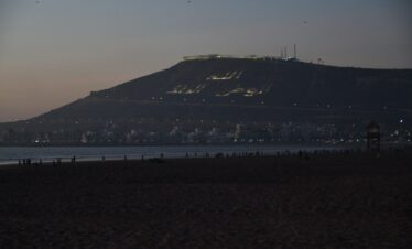 a beach with a hill in the background